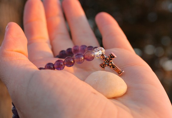 hand with rock and cross