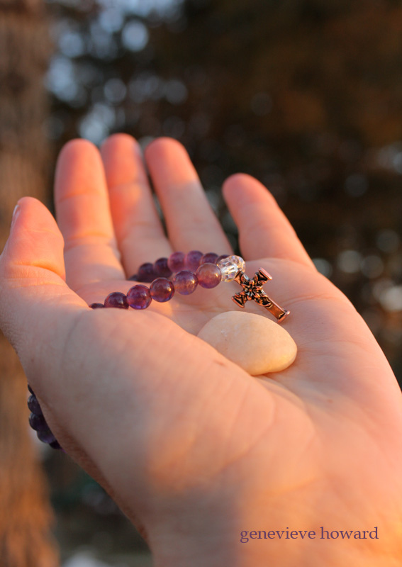 hand with rock and cross