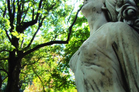 scuplture of woman with green trees